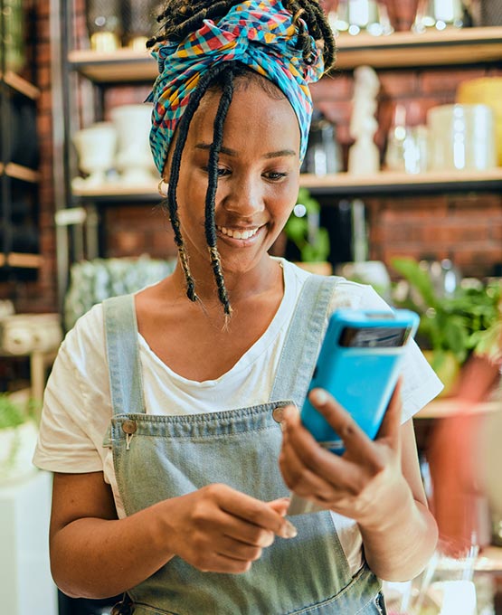 Woman working at a shop swiping a credit card.