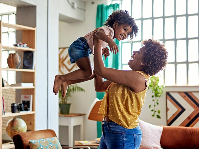 Mom lifting up her child at home.